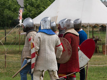 Rear view of people standing on field