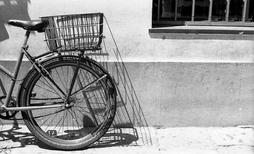 Bicycle leaning on wall of building