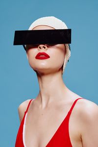 Portrait of young woman wearing hat against clear blue sky