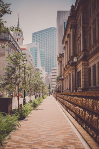 Footpath amidst buildings in city
