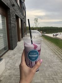 Midsection of person holding ice cream on street