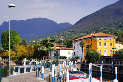 Boats moored at harbor against mountains