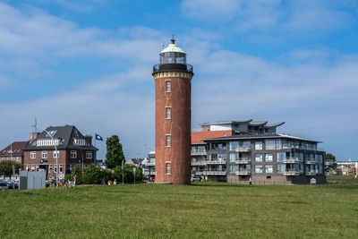 View of buildings in city against cloudy sky