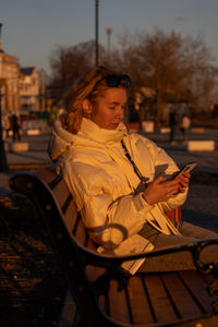 Young woman sitting on bench in park