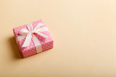 High angle view of gift box against pink background