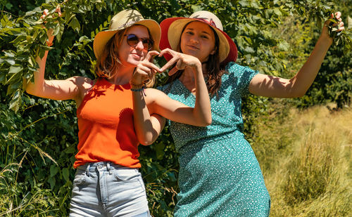 Rear view of woman with arms raised standing on field