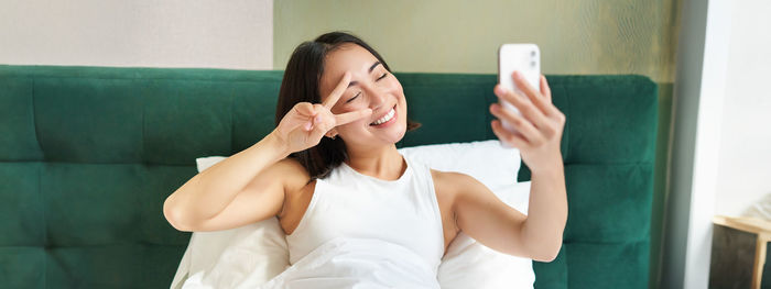 Young woman using mobile phone at home