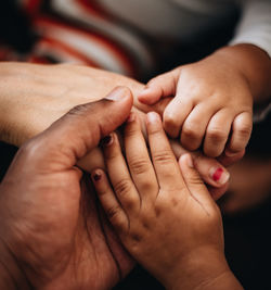 Close-up of stacked hands outdoors