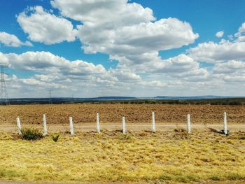 Scenic view of field against cloudy sky