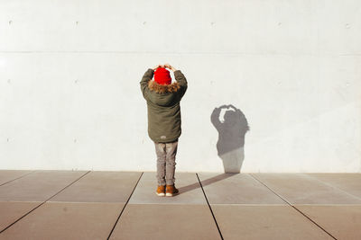 Rear view of boy with shadow on wall