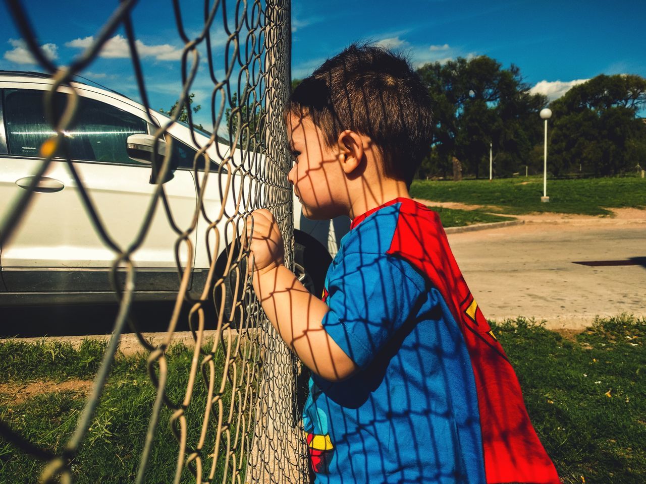 real people, one person, lifestyles, leisure activity, childhood, fence, child, casual clothing, nature, boundary, barrier, chainlink fence, waist up, day, boys, standing, girls, outdoors, hairstyle, scarf