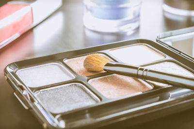 High angle view of brush on highlighter palette on table