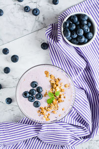 Smoothies with blueberries and granola in a bowl on the table. organic antioxidant healthy food. 