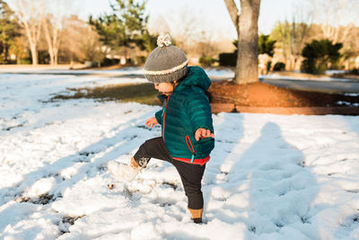 Full length of woman on snow covered tree