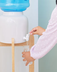 Woman dispensing water from a water tank