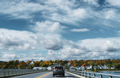 Cars on highway against sky in city