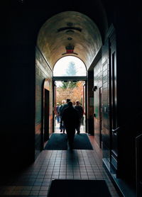 Rear view of man walking in corridor of building