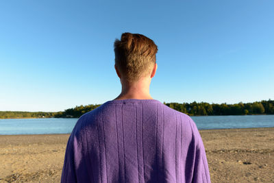 Rear view of man against blue sky