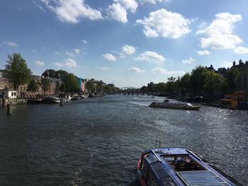 Scenic view of river by buildings against sky