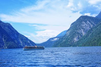 Boat sailing on sea against mountains