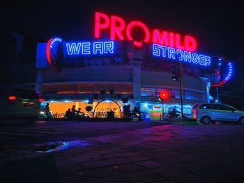 Illuminated sign on road in city at night