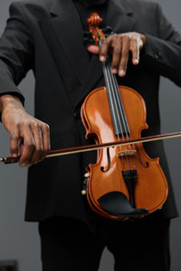 Midsection of man playing violin