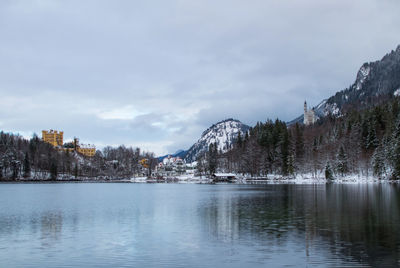 Scenic view of lake by snowcapped mountains against sky