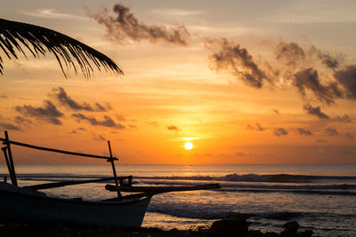 Boat anchored by sea at dusk