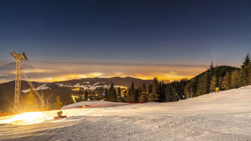 Scenic view of snow covered mountains against sky at night