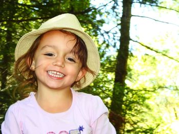 Portrait of smiling girl against trees