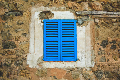 Blue window on wall of old building