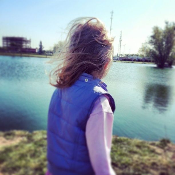 water, lifestyles, leisure activity, long hair, focus on foreground, blond hair, rear view, childhood, girls, casual clothing, person, brown hair, standing, elementary age, lake, medium-length hair, day, waist up