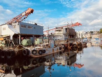 Cranes at harbor against sky