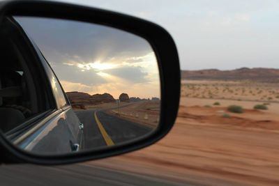 Reflection of sunset on side-view mirror