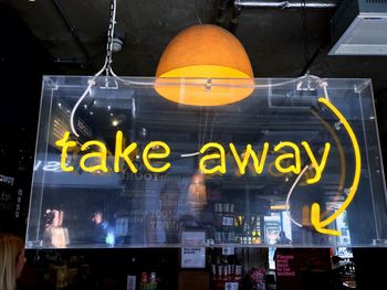 Illuminated text on glass window at night