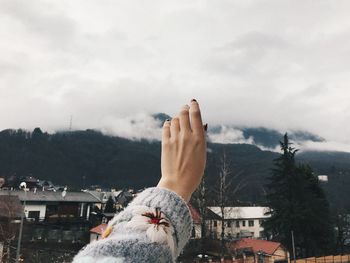 Person with arms outstretched against mountain range