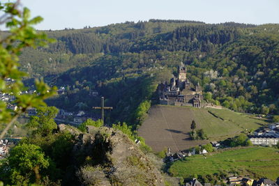 High angle view of castle amidst trees and mountains 