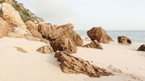 Rocks on beach against sky