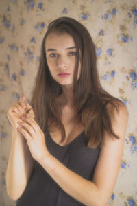 Portrait of young woman against wall