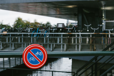 Close-up of road sign by railing