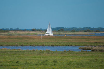 Boat sailing on lake against clear sky