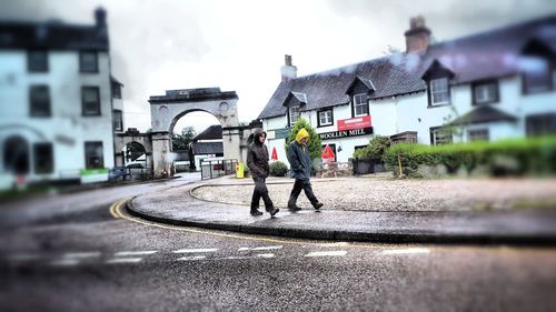 Man walking on road against buildings in city