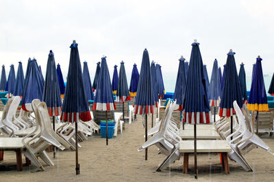 Chairs on beach against sky