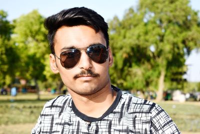 Portrait of young man wearing sunglasses standing outdoors