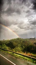 Scenic view of rainbow over road against sky