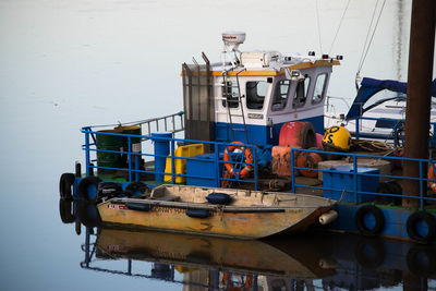 Fishing boat moored at harbor against sky