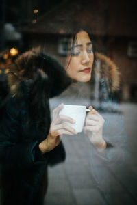 Woman looking at camera while standing in winter