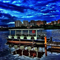 Pier in river against cloudy sky