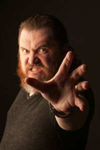 Portrait of man against black background