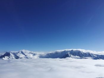 Scenic view of snowcapped mountains against clear blue sky